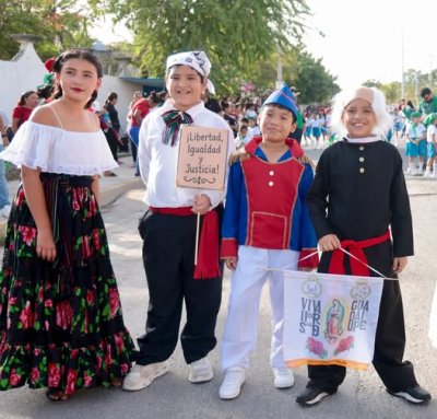 Atenea Gómez Ricalde acompaña a niños en desfile de la Independencia